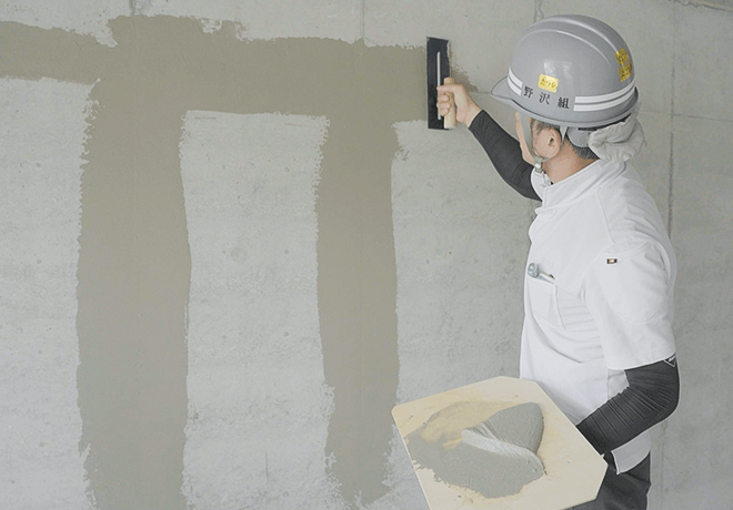 コテと手板を使って塗り上げる職人